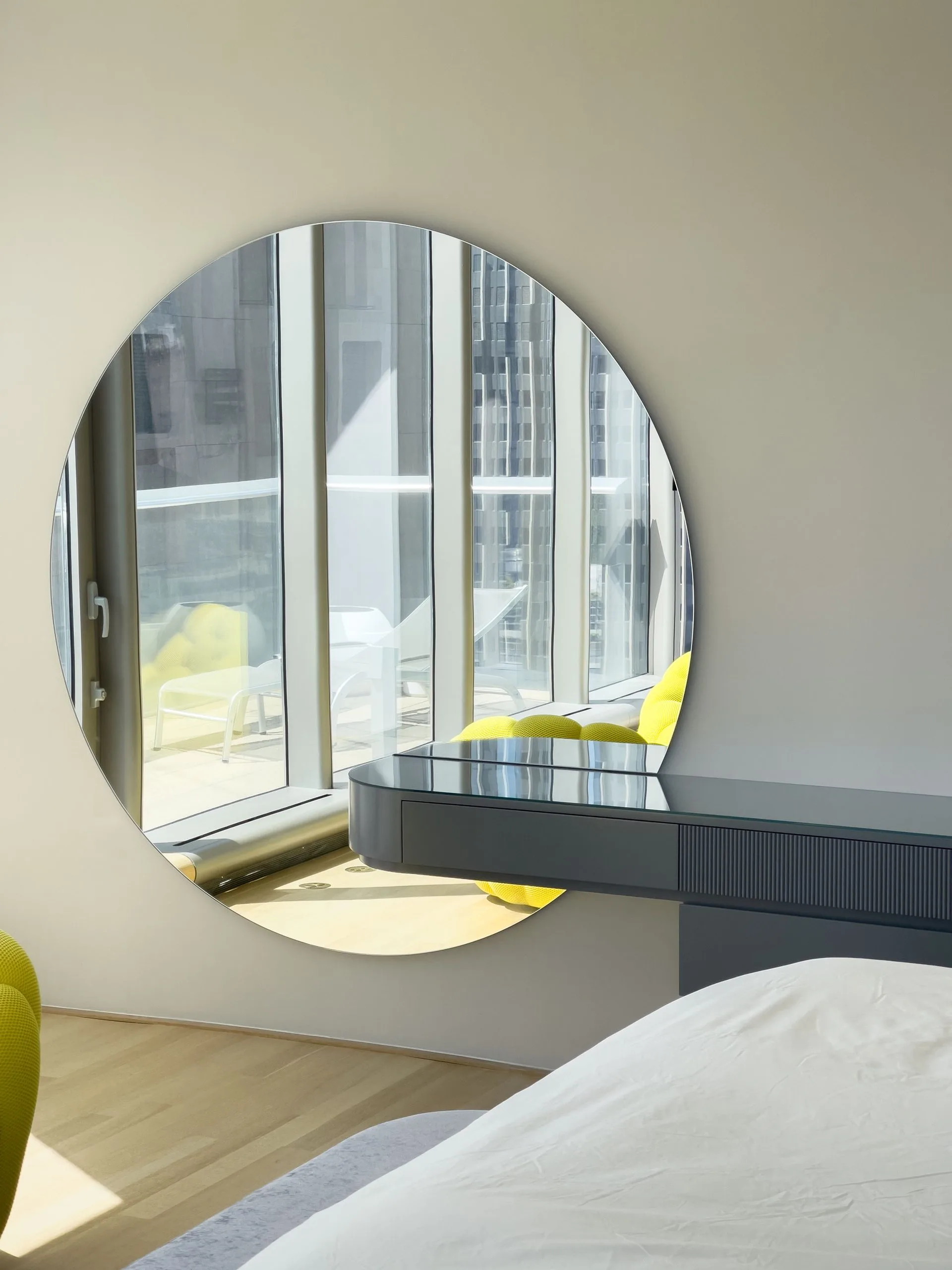Six-foot round mirror with a millimeter-precise cutout meeting the floating console