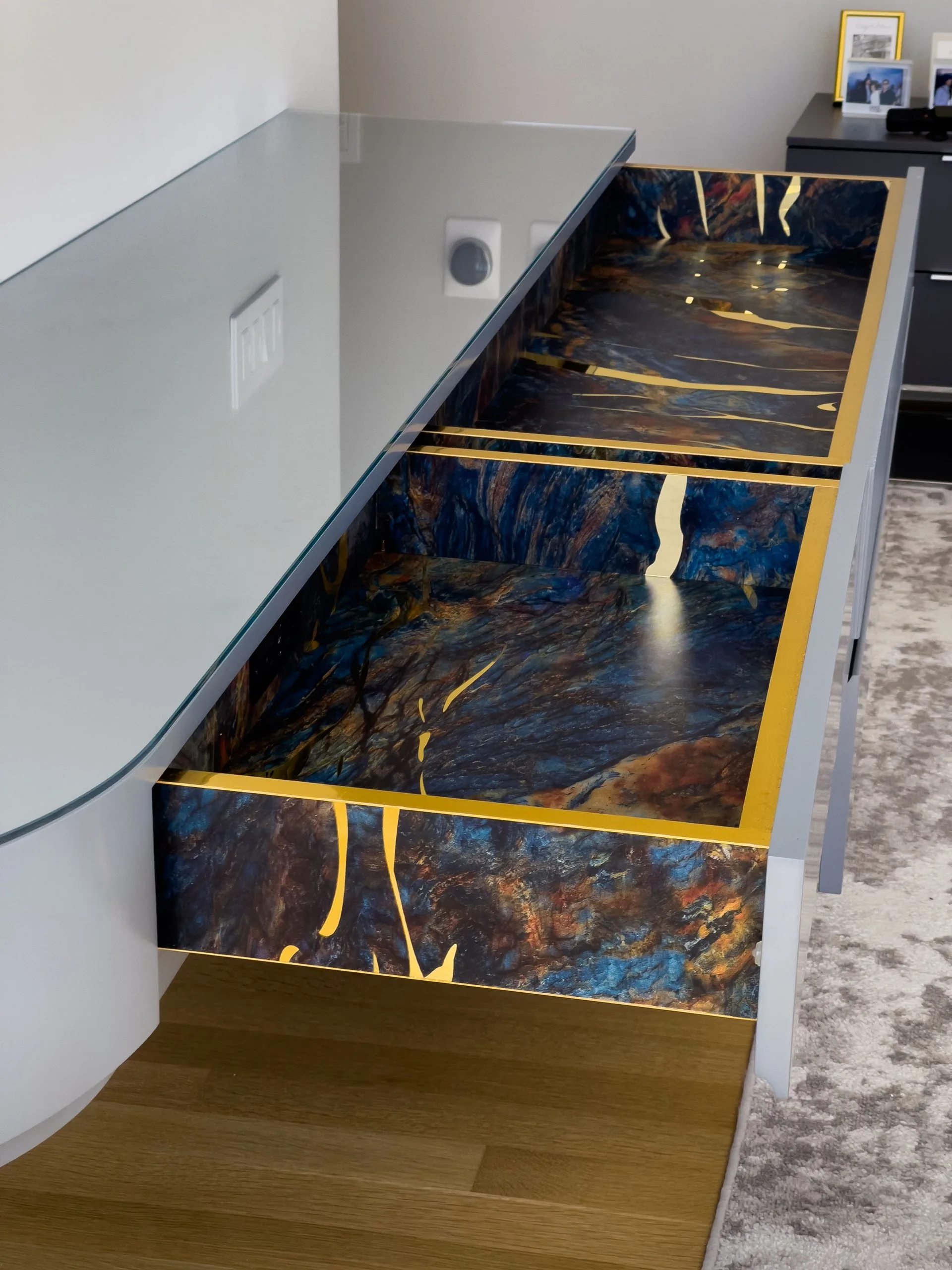 Open drawer of the HER console, colorful hand-painted interior with brass inlay