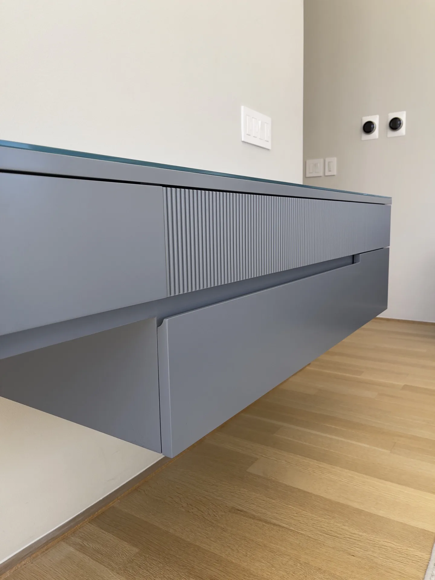 Integrated finger pull, a channel cut into the drawer front edges of the custom floating console