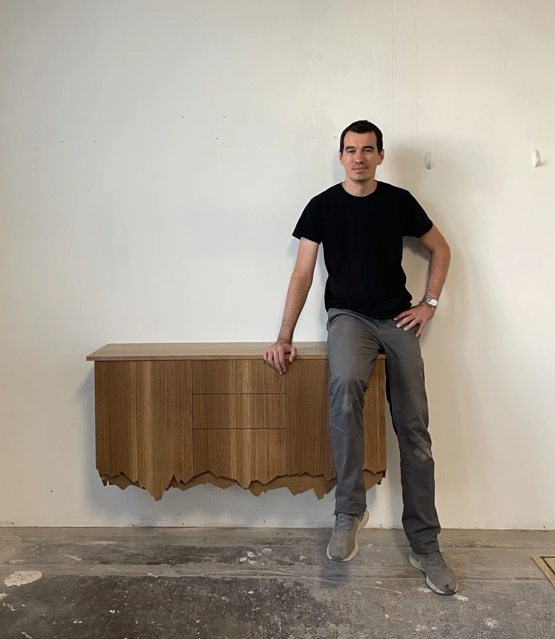 Nikolay, founder of Wewillbebirds, with a fluted console in the Brooklyn shop