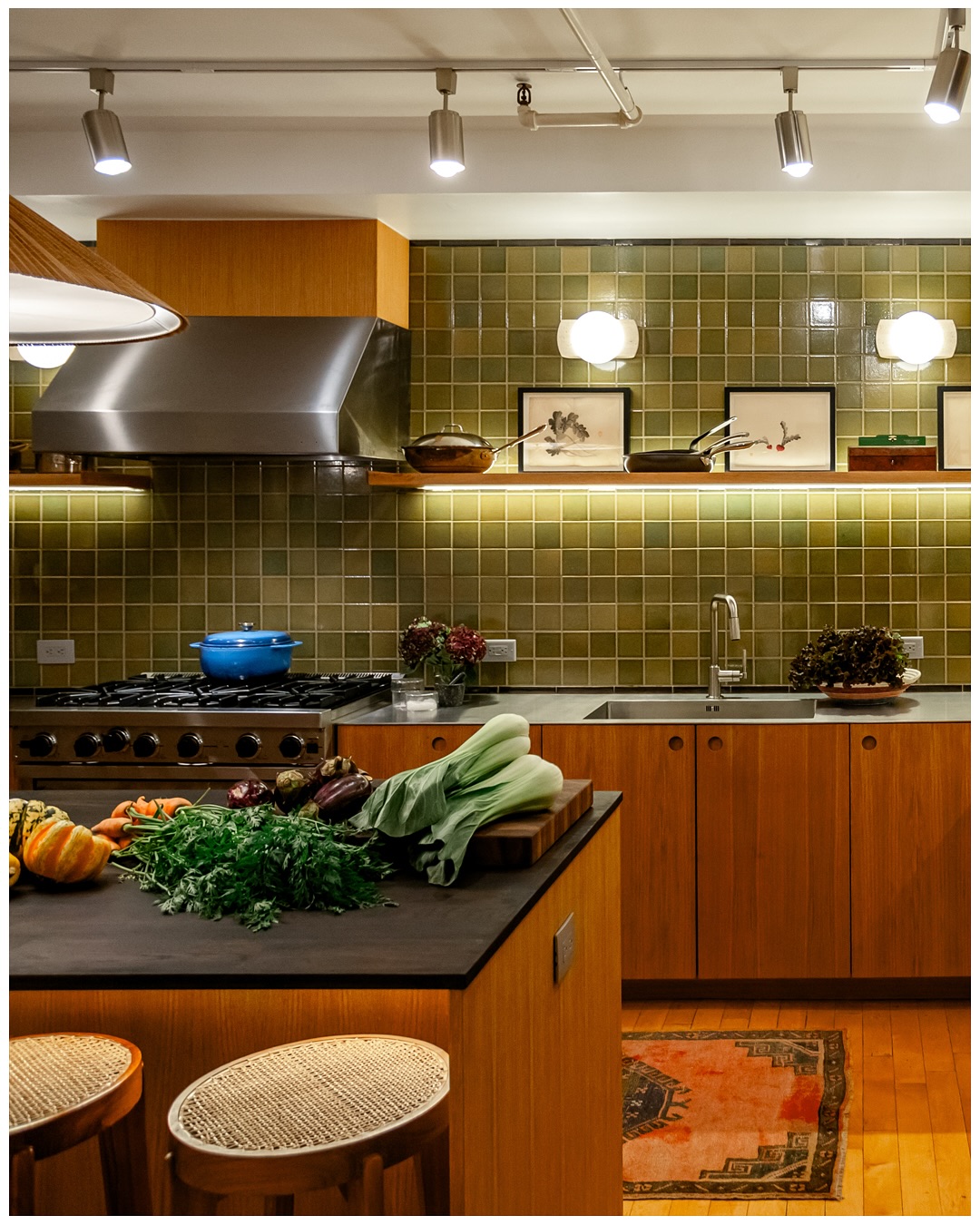 Range wall with vegetables on the counter and a warm pendant overhead