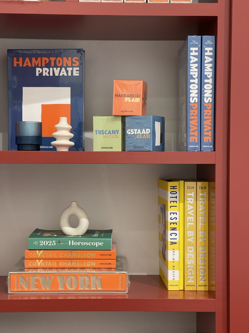 Display shelf with travel and design books styled against terracotta millwork