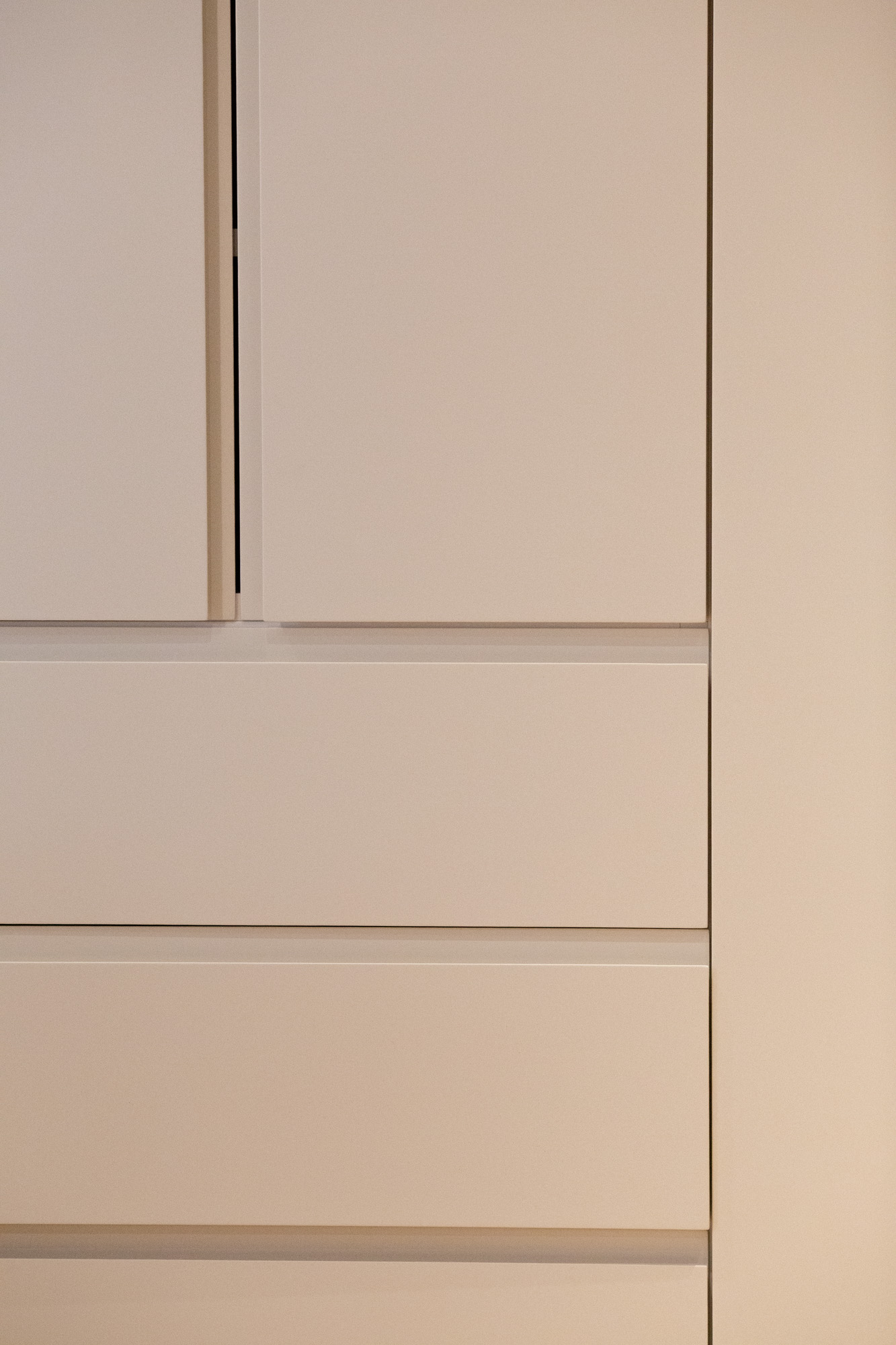 Recessed shadow lines between painted doors and drawer fronts