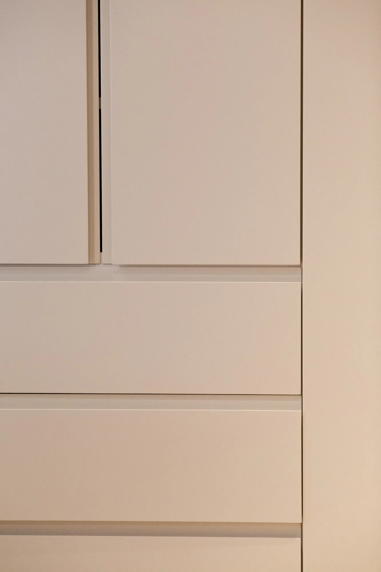 Recessed shadow lines between painted doors and drawer fronts