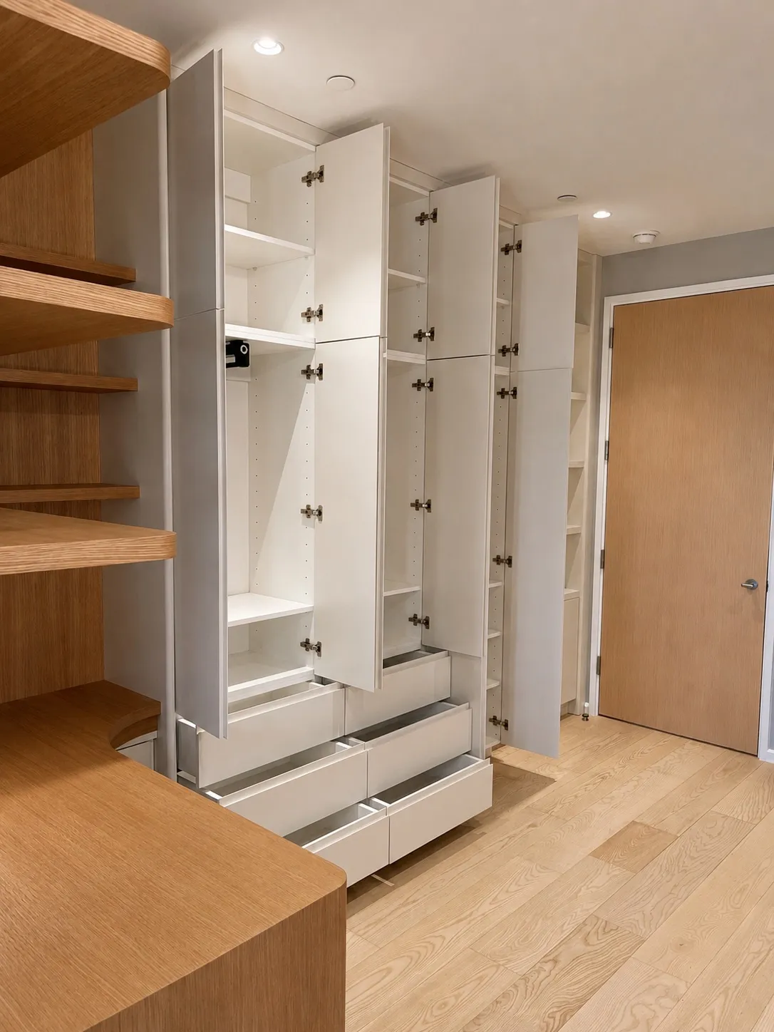 The same wall with every door and drawer open, revealing the full storage system